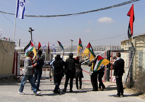 ناشطون يرفعون العلم الفلسطيني على بوابة معسكر للاحتلال