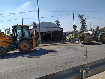 الاحتلال يهدم محلا تجاريا ويزيل بسطات خضار ويخطر بهدم 5 منشآت قرب حاجز "الجلمة"